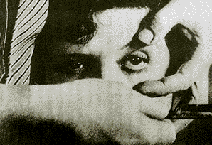 ルイス・ブニュエル＋ダリ「アンダルシアの犬」（1928）より。男の左手が女性の眼球を広げる。男は右手に剃刀をもっている。この後，月をスーッと横切る一筋の雲のカットが入り，次にスーッと剃刀で切り裂かれる眼球のアップのカットとなる